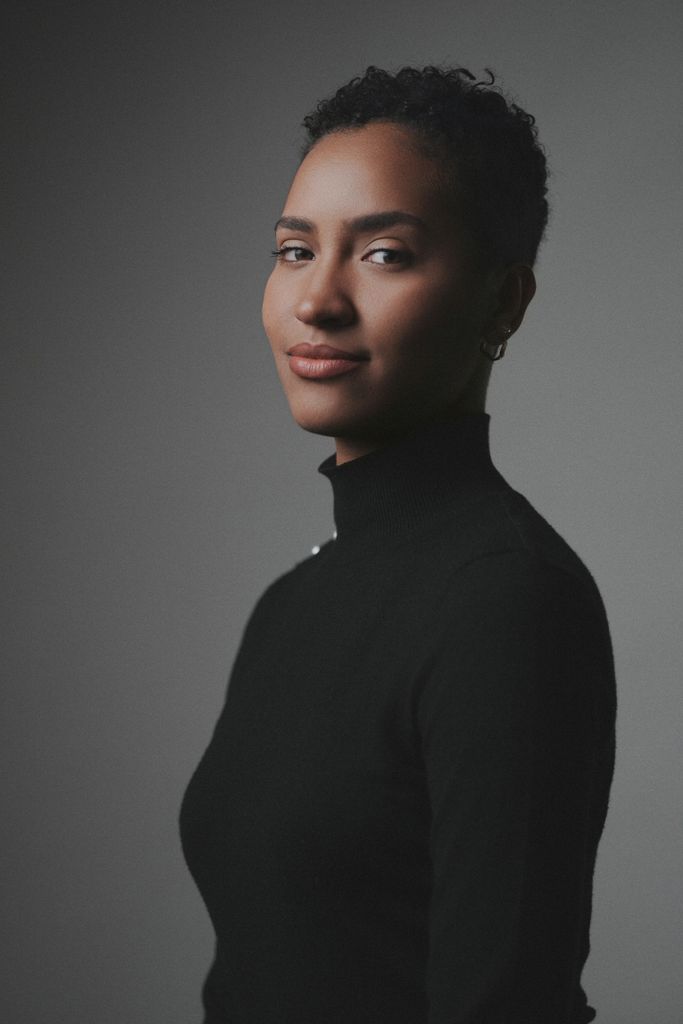 Classic studio portrait of a woman in a black turtleneck, exuding elegance and confidence.