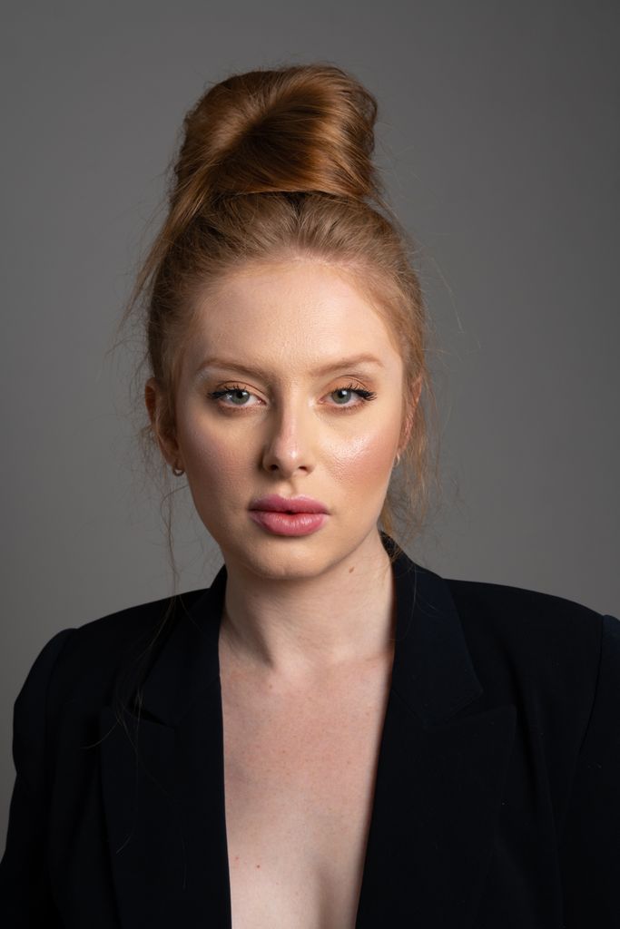 Sophisticated portrait of a young woman in São Paulo with an elegant updo hairstyle and stylish blazer.